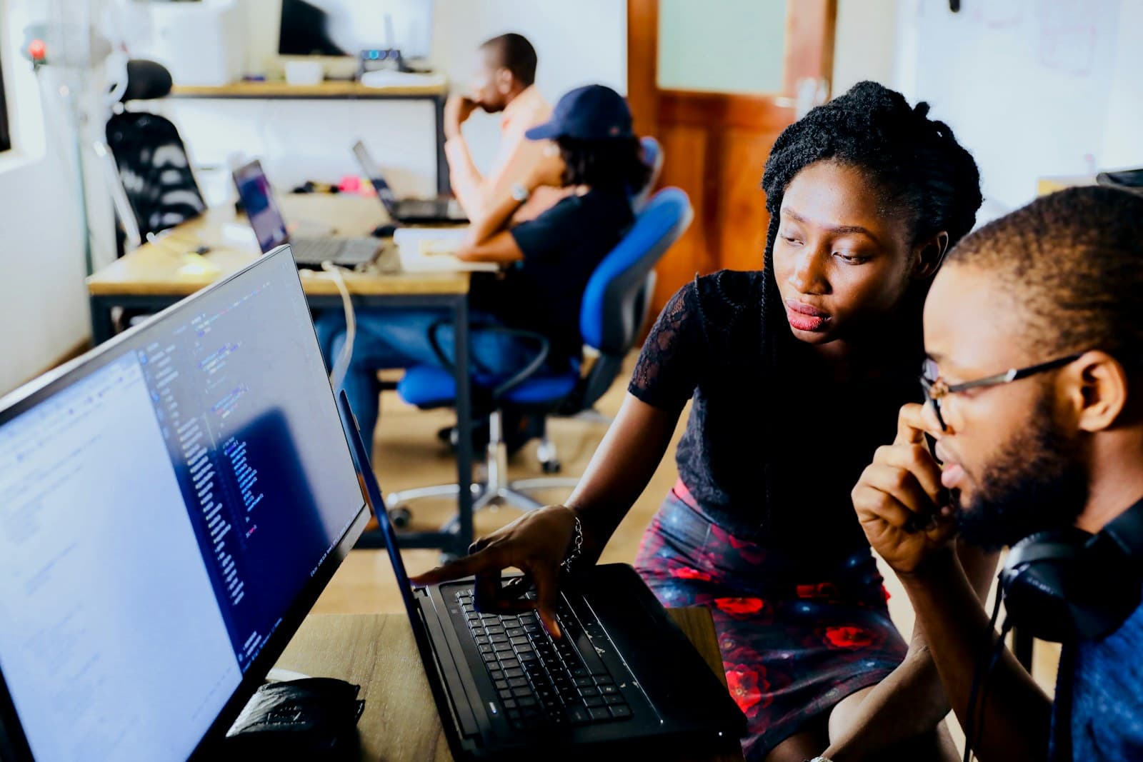 African technology professionals collaborating around a laptop
